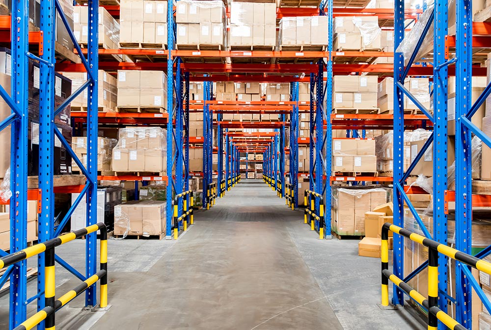 A view of a large warehouse full of racking and pallets of stock and cardboard boxes